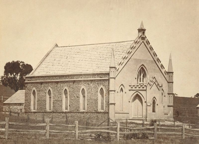 Sepia photograph of John Knox Free Presbyterian Church — a stone Gothic Revival church with pointed arched windows and door, decorative crenellated parapet, slate roof, and a fleche at the peak